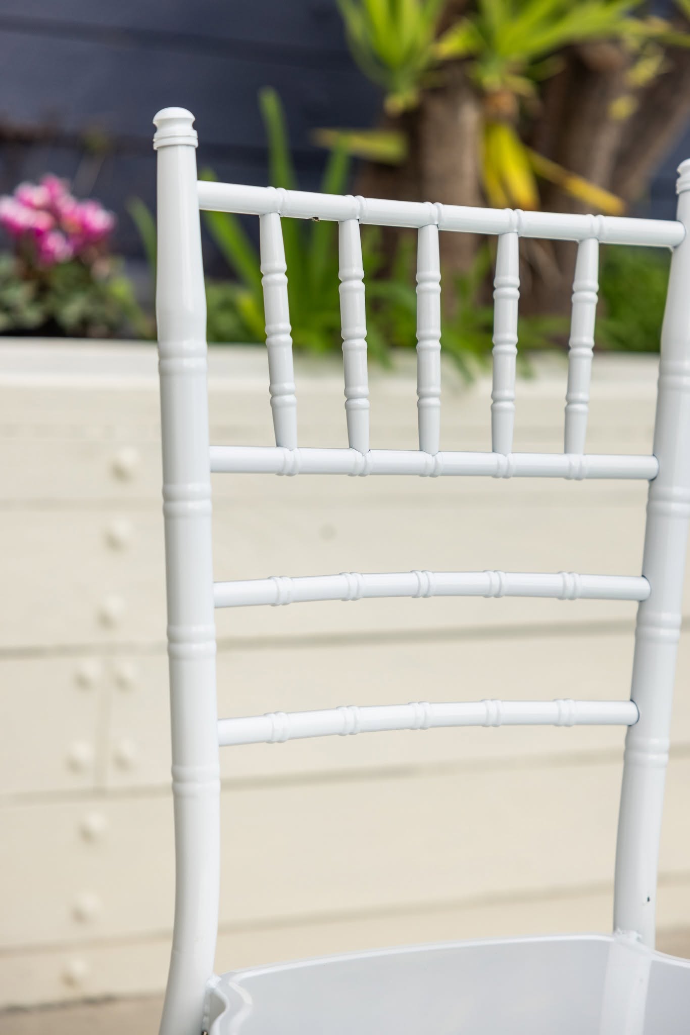 Close-up of a white Chiavari chair back showing the bamboo-style turned frame and slatted rails
